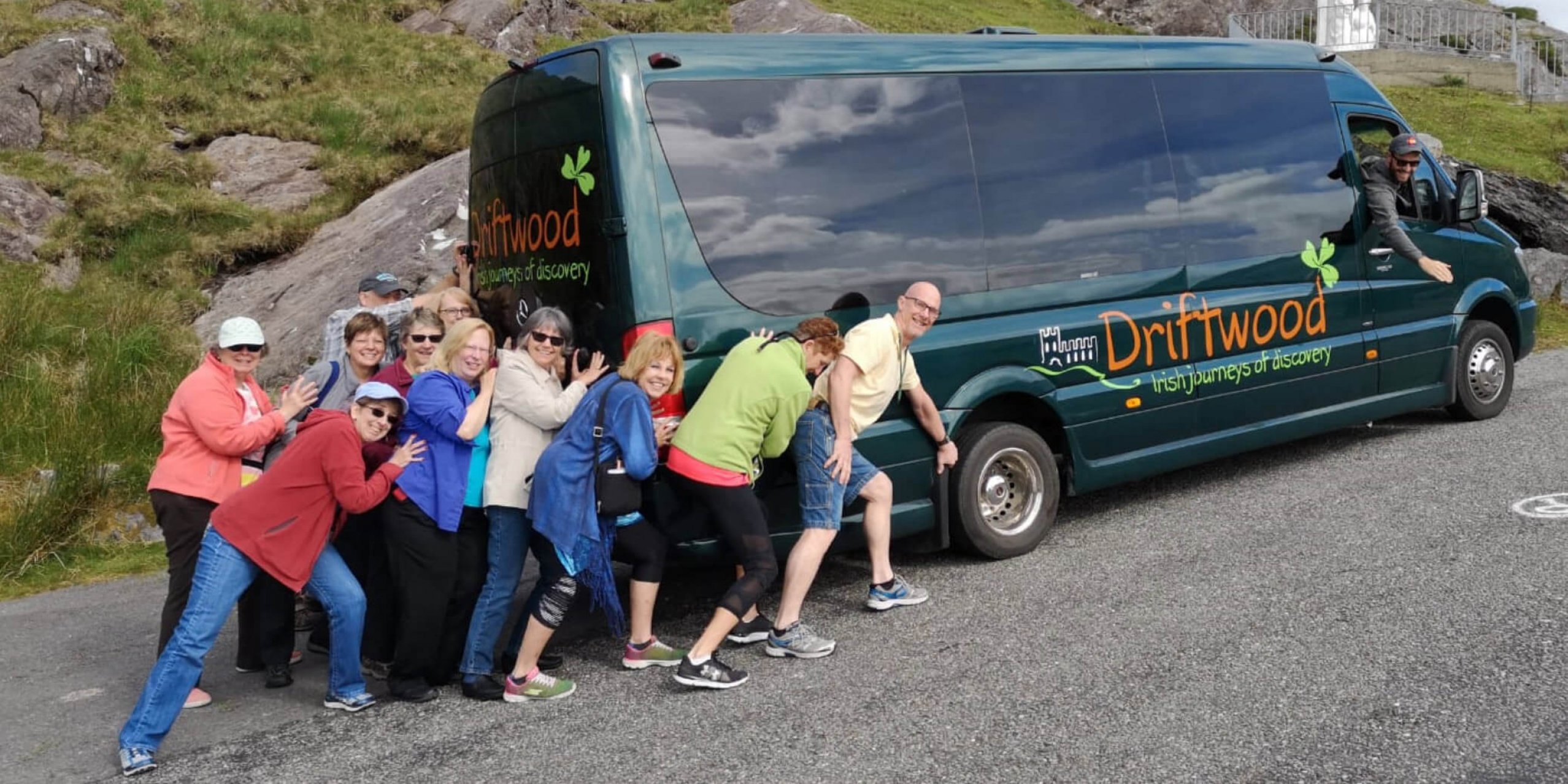 A funny photo of a group of Driftwood guests pretending to push their Drifter tour vehicle uphill