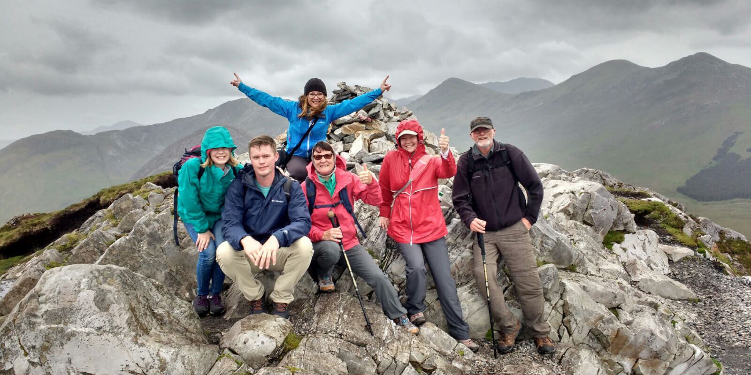 Colourful group posing at the summit of Diamond Hill in Connemara
