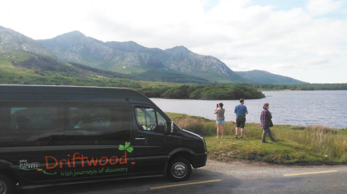 Drifter tour vehicle with guests looking at a stunning Connemara landscape