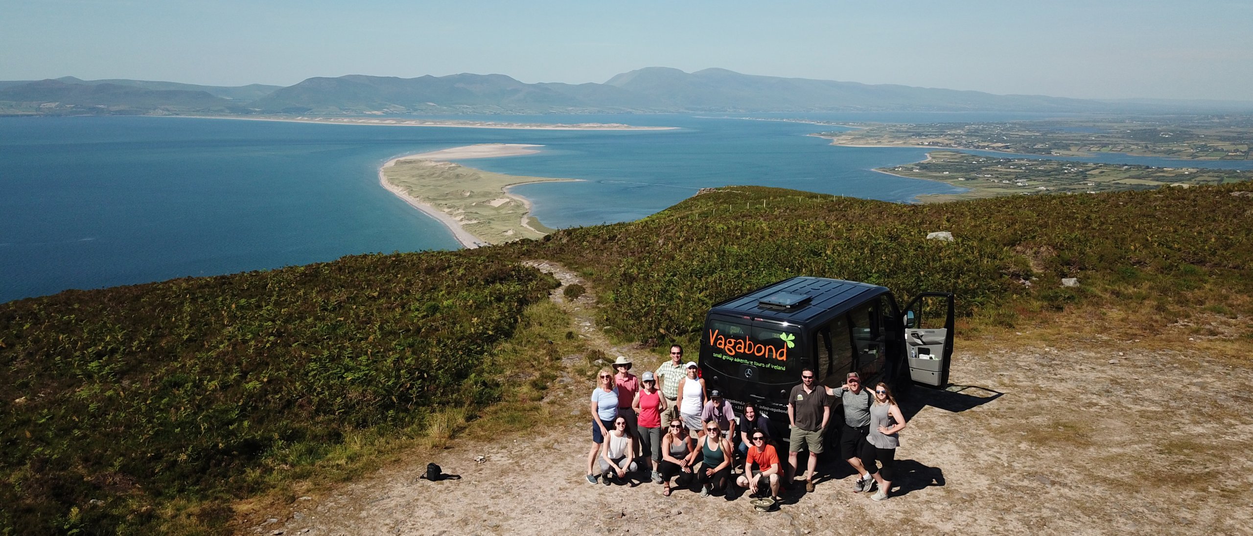 Vagabond VagaTron Tour Vehicle and group posing at Rossbeigh in Kerry