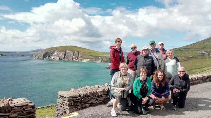 A group of guests posing on Slea Head in the sunshine overlooking the sea