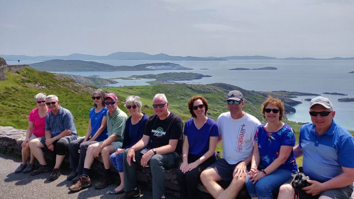 A group of guests sitting on a wall overlooking the Ring of Kerry