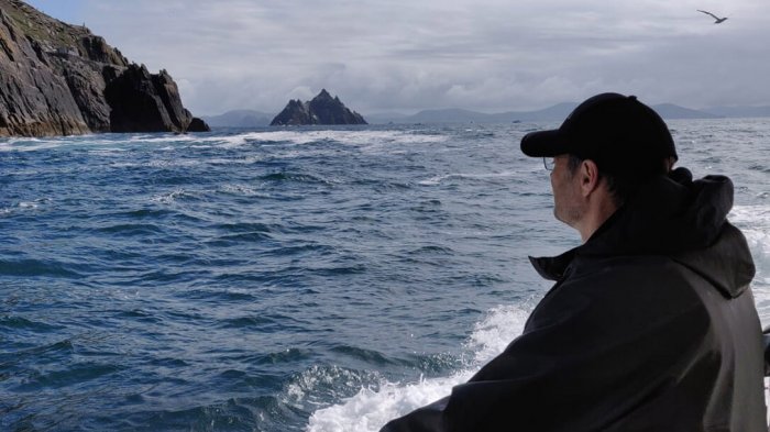 A man on the Skellig Island cruise looking from the boat at Skellig Michael