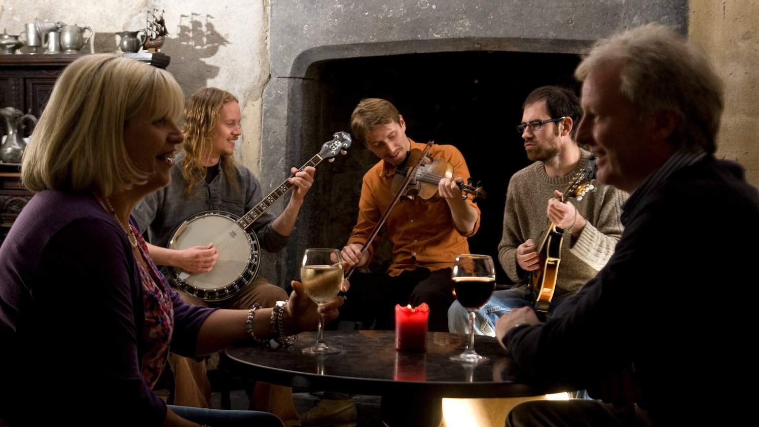 A couple enjoy three Irish traditional musicians in a bar